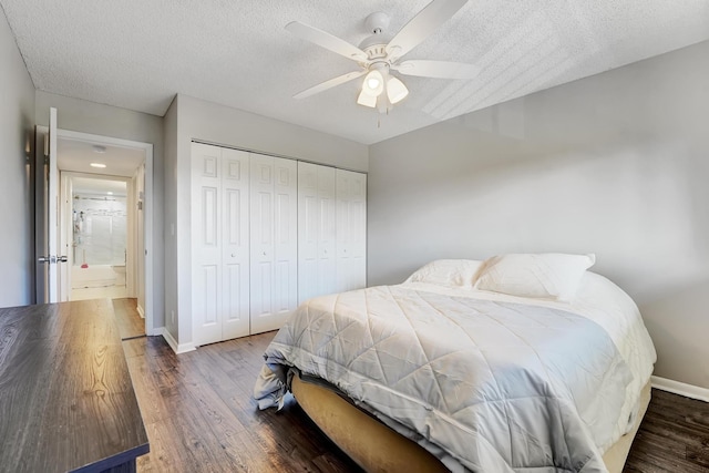 bedroom with ceiling fan, dark hardwood / wood-style floors, a textured ceiling, and a closet