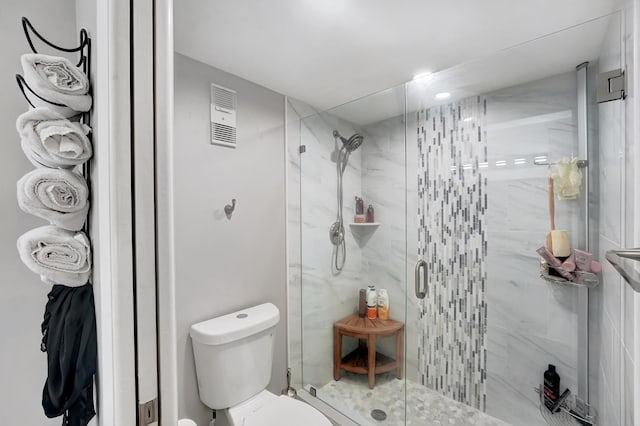 bathroom featuring an enclosed shower and toilet