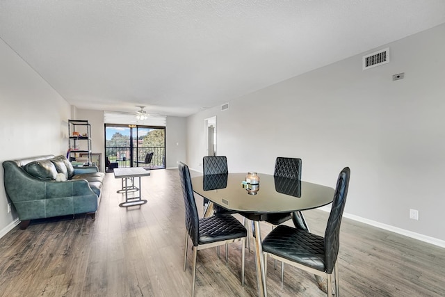 dining space featuring hardwood / wood-style floors, a textured ceiling, and ceiling fan