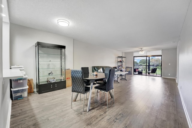 dining room featuring ceiling fan, a textured ceiling, and hardwood / wood-style flooring