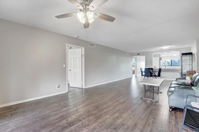 living room with a textured ceiling, ceiling fan, and dark hardwood / wood-style floors