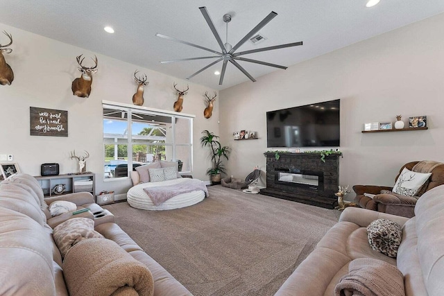 living room with carpet flooring, a fireplace, a textured ceiling, and ceiling fan