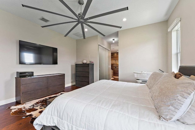 bedroom with a textured ceiling, dark wood-type flooring, and ceiling fan