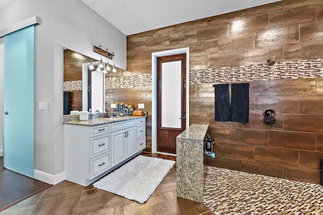 bathroom featuring a shower, tile patterned flooring, vanity, and tile walls