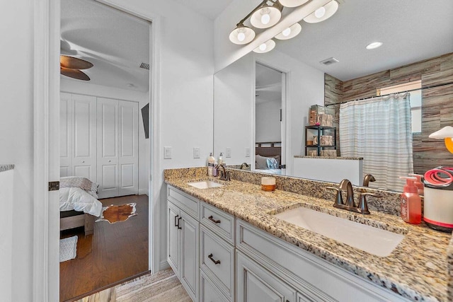 bathroom with walk in shower, wood-type flooring, and vanity