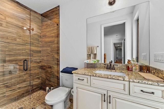 bathroom with vanity, a textured ceiling, toilet, and a shower with shower door