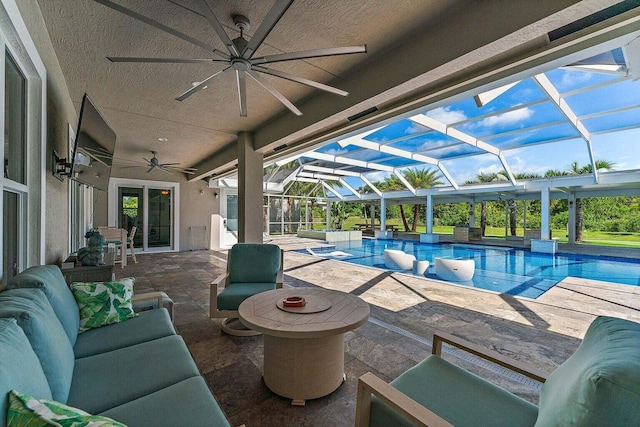 view of pool with outdoor lounge area, a patio, glass enclosure, and ceiling fan