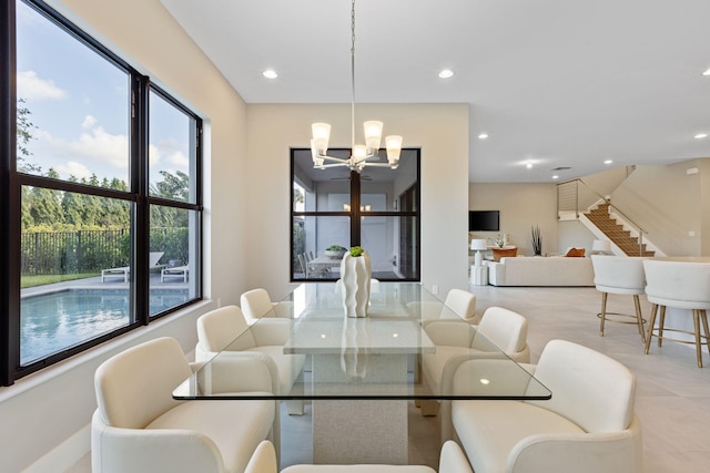 dining room featuring a wealth of natural light, light tile patterned flooring, and a notable chandelier