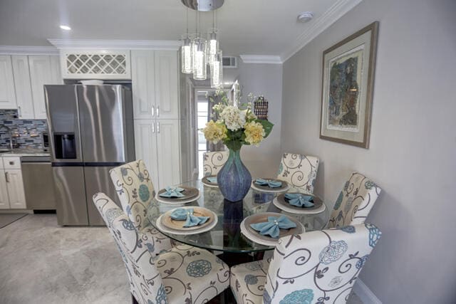 dining area featuring a chandelier and crown molding