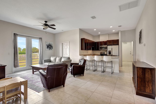 tiled living room with french doors, ceiling fan, and sink