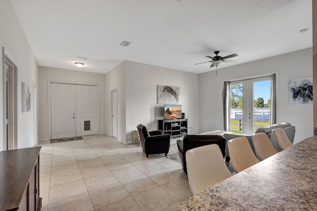 interior space featuring ceiling fan, french doors, and light tile patterned floors