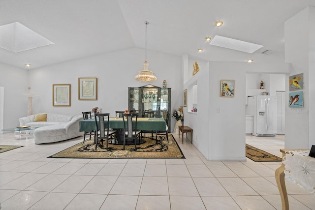 dining room featuring light tile patterned flooring, built in shelves, and vaulted ceiling with skylight