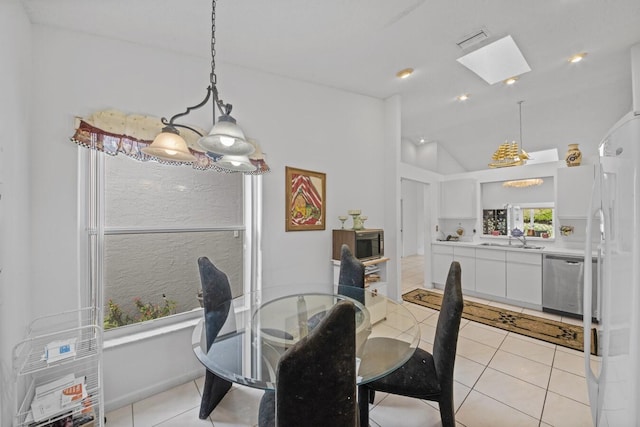 tiled dining space featuring vaulted ceiling and sink