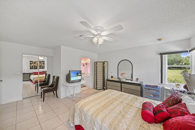 tiled bedroom featuring ceiling fan and a textured ceiling