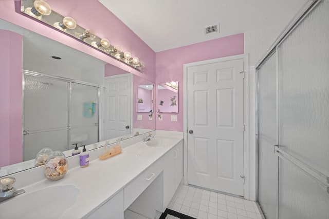 bathroom featuring tile patterned floors, a shower with door, and vanity