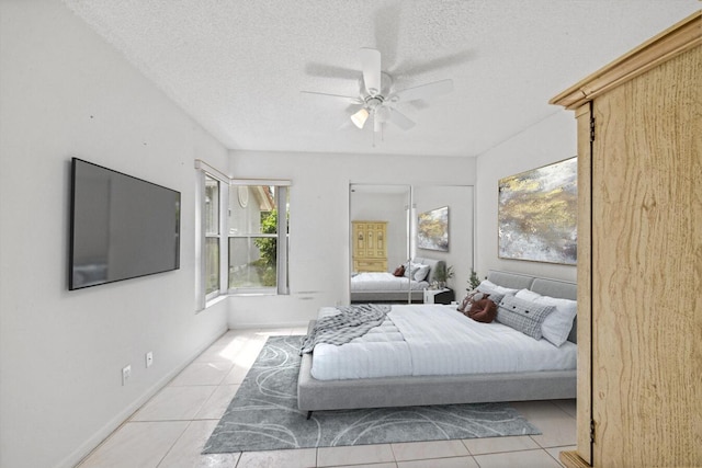 tiled bedroom with a textured ceiling and ceiling fan