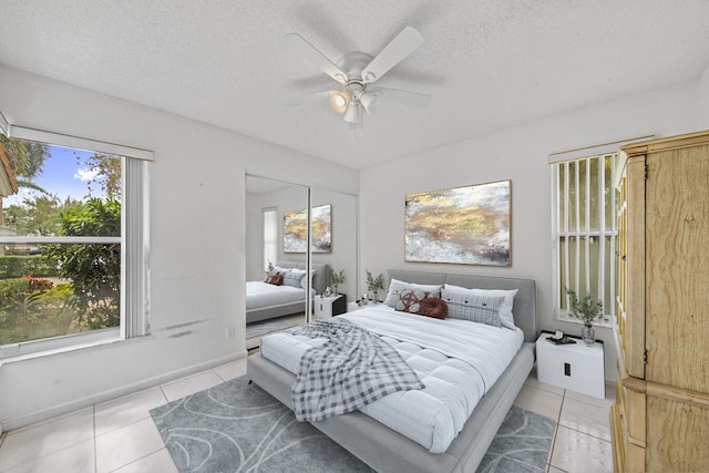 tiled bedroom featuring a textured ceiling, a closet, and ceiling fan