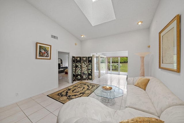 tiled living room featuring a skylight and high vaulted ceiling