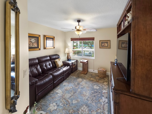 carpeted living room featuring ceiling fan and a textured ceiling