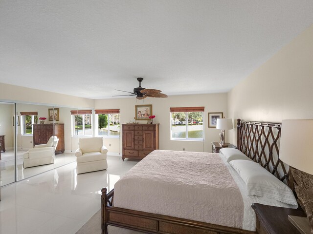 sunroom / solarium featuring a water view and ceiling fan