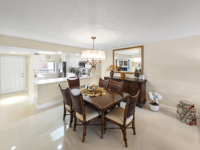 kitchen with light tile patterned flooring, appliances with stainless steel finishes, a textured ceiling, sink, and white cabinets