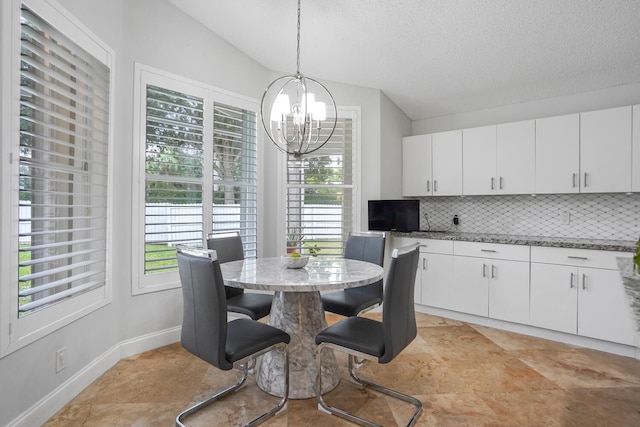 dining area featuring lofted ceiling, a textured ceiling, and a chandelier