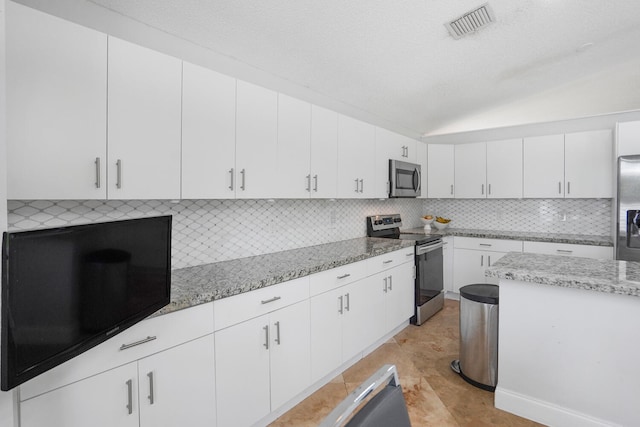 kitchen with light tile patterned floors, tasteful backsplash, light stone counters, white cabinets, and appliances with stainless steel finishes