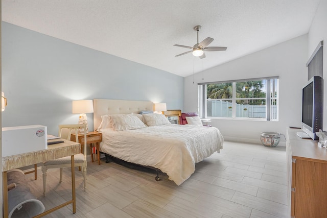 bedroom with a textured ceiling, ceiling fan, and lofted ceiling