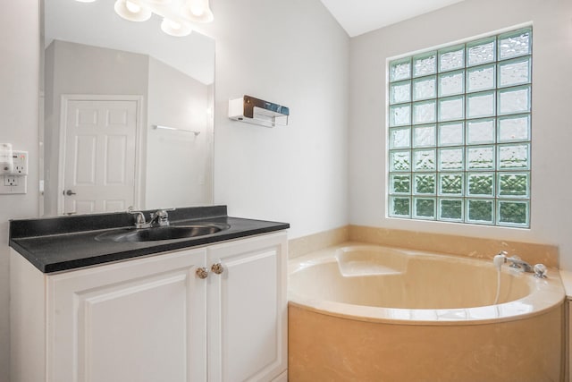 bathroom featuring vanity and a bath