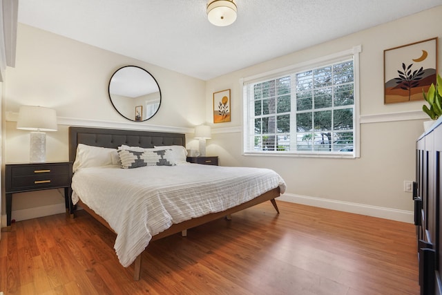 bedroom featuring wood-type flooring and a textured ceiling