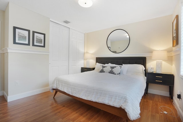 bedroom with wood-type flooring and a closet