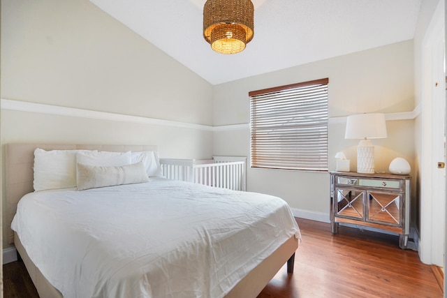 bedroom featuring vaulted ceiling and dark hardwood / wood-style floors