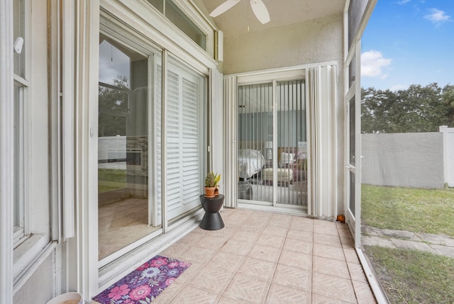 unfurnished sunroom with ceiling fan