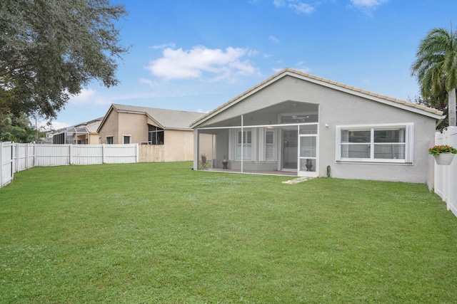 rear view of property featuring a sunroom and a yard