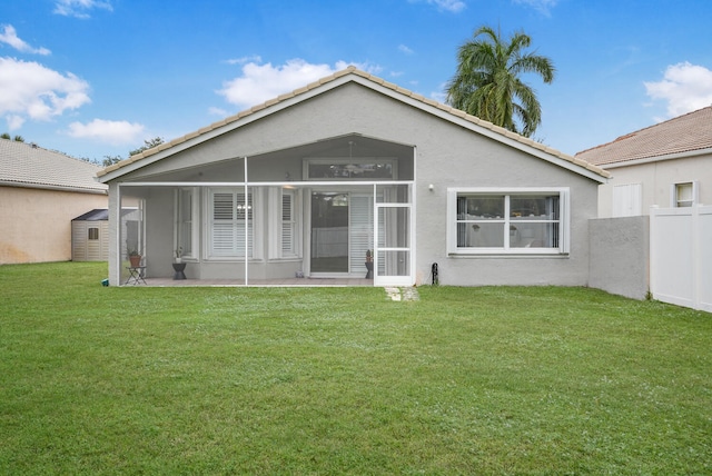 back of property with a sunroom and a yard