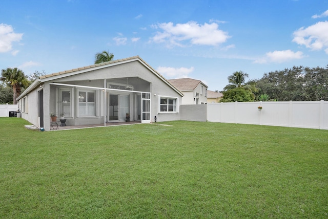 back of property featuring a sunroom, central AC unit, and a lawn