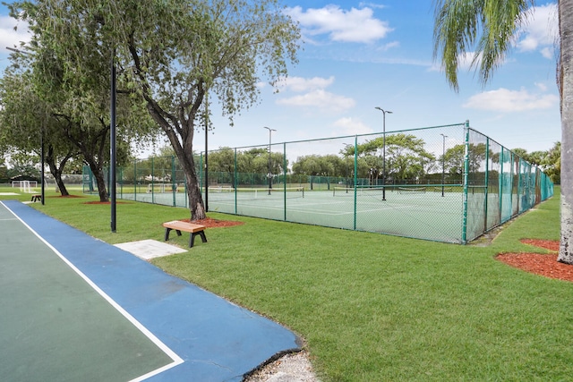 view of tennis court featuring a yard