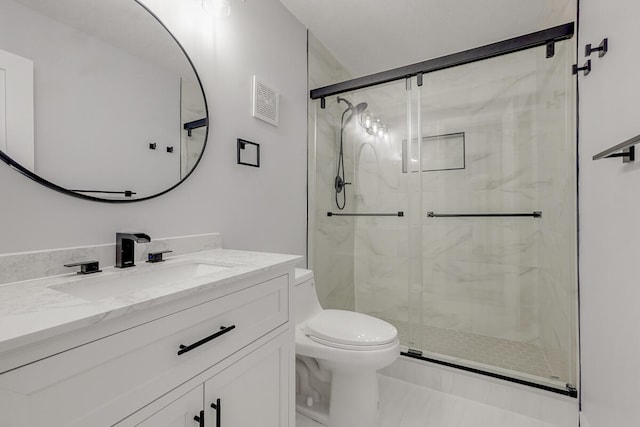 bathroom featuring vanity, toilet, and a shower with shower door