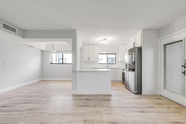 kitchen with white cabinets, sink, appliances with stainless steel finishes, and light hardwood / wood-style flooring