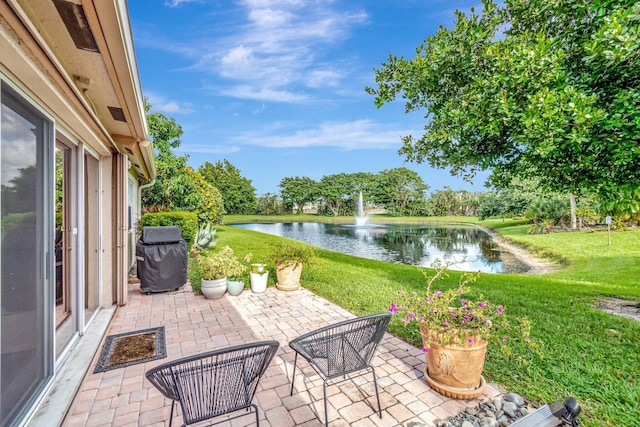 view of patio featuring area for grilling and a water view