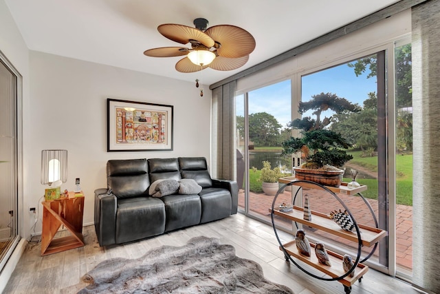 living room featuring ceiling fan and light hardwood / wood-style flooring