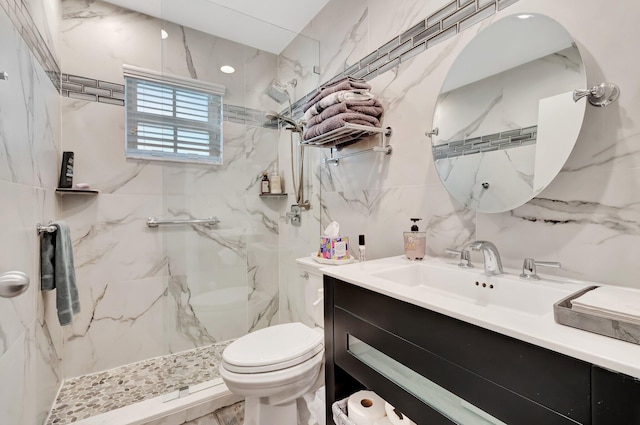 bathroom with a tile shower, vanity, and toilet