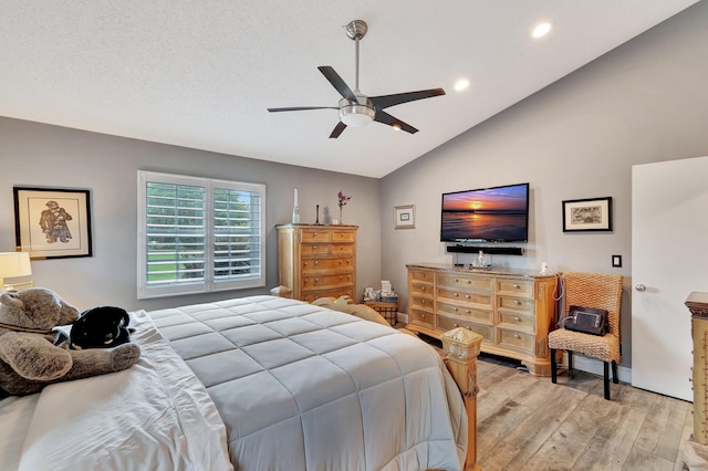 bedroom featuring ceiling fan, light wood-type flooring, and vaulted ceiling