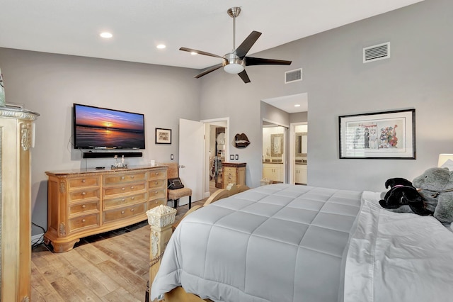 bedroom featuring connected bathroom, ceiling fan, light hardwood / wood-style flooring, and vaulted ceiling