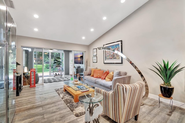 living room featuring lofted ceiling and light hardwood / wood-style flooring