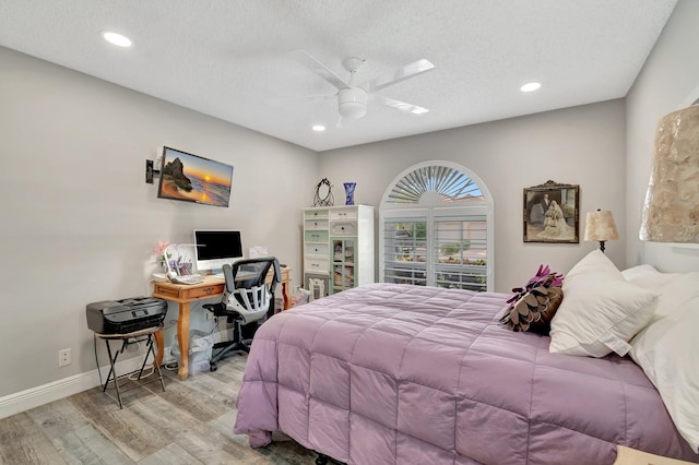 bedroom featuring a textured ceiling, light hardwood / wood-style floors, and ceiling fan