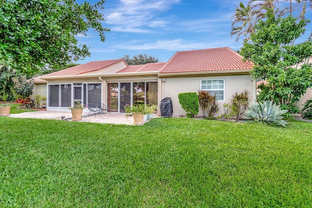 back of house featuring a lawn, a patio area, and a sunroom