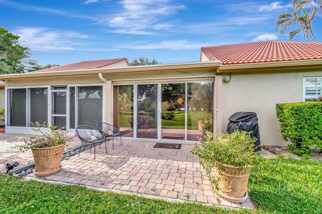 rear view of property with a patio area and a sunroom