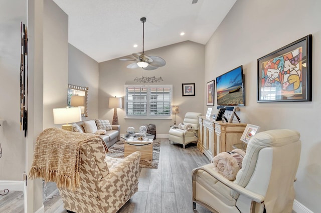 living room with ceiling fan, light hardwood / wood-style floors, and high vaulted ceiling