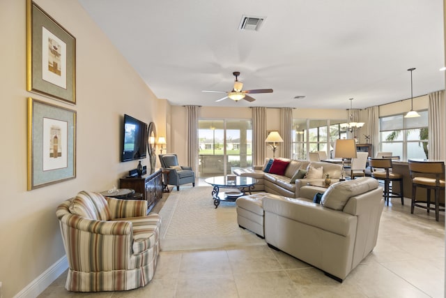 living room with ceiling fan with notable chandelier and light tile patterned floors